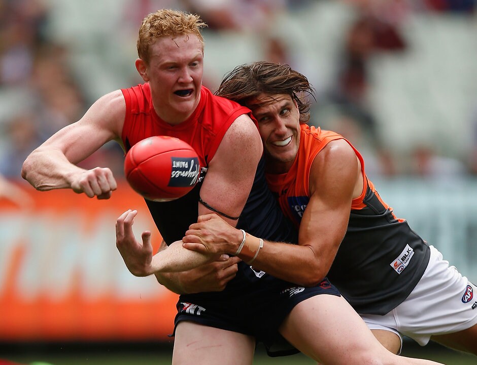AFL 2016 Rd 01 - Melbourne v GWS Giants MELBOURNE, AUSTRALIA - MARCH 26: Clayton Oliver of the Demons is tackled by Ryan Griffen of the Giants during the 2016 AFL Round 01 match between the Melbourne Demons and the GWS Giants at the Melbourne Cricket Ground, Melbourne on March 26, 2016. (Photo by Sean Garnsworthy/AFL Media)